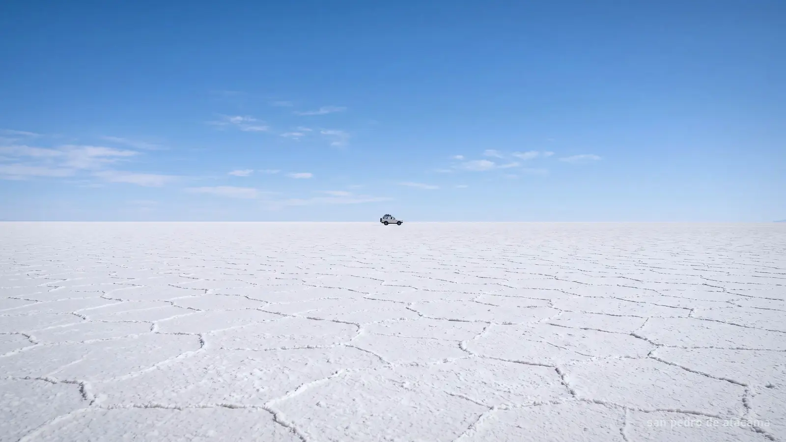 A flat white salt plain meeting the sky at a hard horizon line